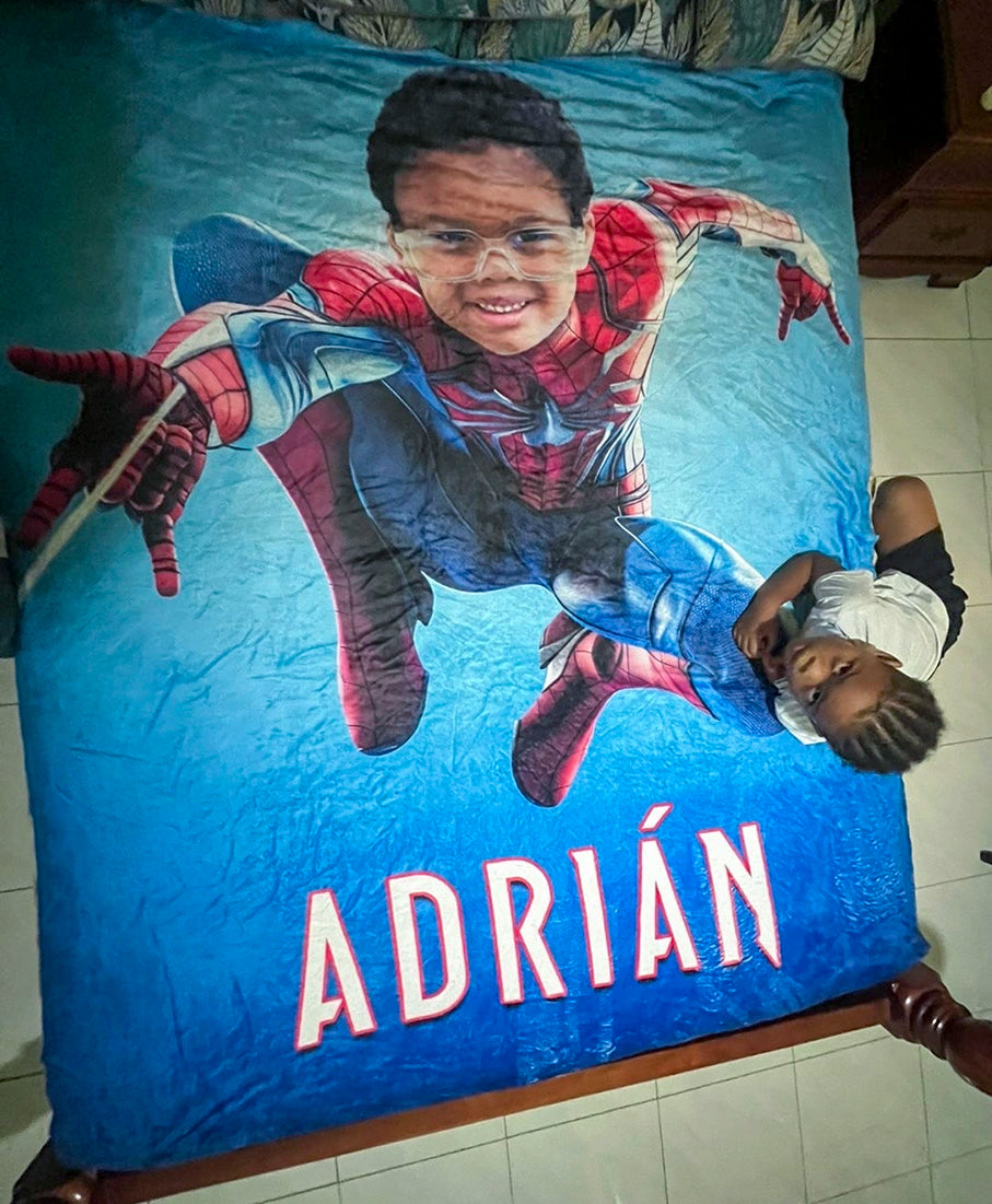 kid with his superhero blanket on a bed