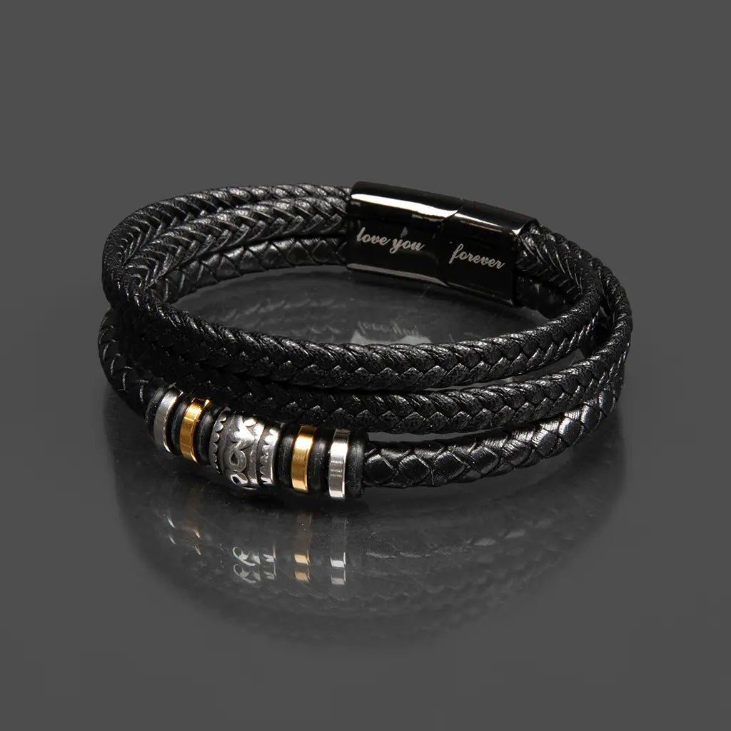Black braided leather bracelet with metal beads on a reflective gray surface